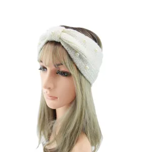 White knit headband with pearl embellishment, cross bow design, warm winter hair accessory.