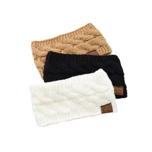 Detailed view of cozy cable knit headbands in beige, black, and white with chic logo patches.