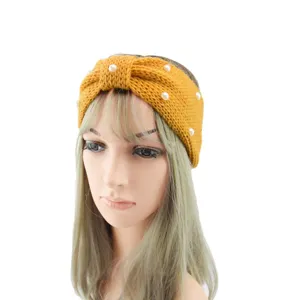 Close-up detail of yellow knit headband adorned with elegant white pearls and a stylish bow knot.