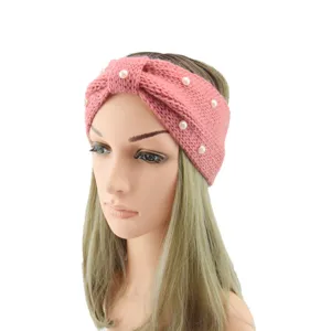 Close-up detail of the pink knitted wool headband featuring elegant pearls and bow design.