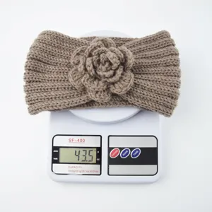 Detailed view of the knitted floral headband showing its handmade crochet flower texture.