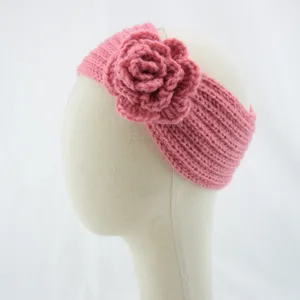 Pink knitted headband detail showing soft wool texture and handmade crochet flower.