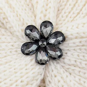 Nahaufnahme der Damen Strickmütze mit funkelndem grauen Kristallblumen-Strass-Besatz.