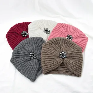 Detailansicht gemütlicher Strickturbanhüten mit Kristallblumenverzierung in verschiedenen Farben.