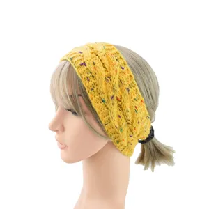 Dettaglio ravvicinato della fascia in maglia gialla con macchie colorate, accessorio per capelli.