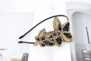 Detailansicht des exquisiten Haarreifs mit schwarzen und goldenen Perlen und Kristallen.