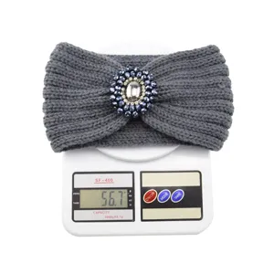 Gray knitted headband with sparkly gemstone brooch, detailed weight display on digital scale.