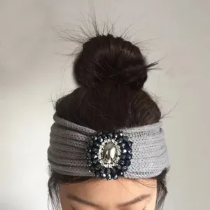 Primo piano dettaglio della fascia in maglia grigia con decorazione di cristalli strass.