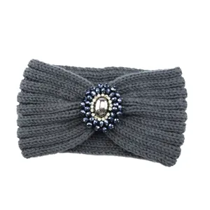 Detailed view of a dark gray knitted winter headband with a sparkling rhinestone brooch centerpiece.