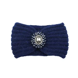 Detailed close-up of dark blue knitted winter headband with rhinestone crystal center brooch design.