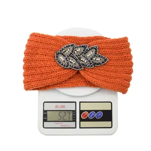 Orange knitted headband with rhinestone leaf winter warm hair accessory detail view