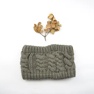 Gros plan du bandeau en tricot torsadé vert gris avec texture riche et style automnal.