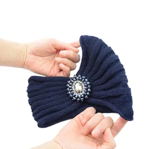Fascia in maglia blu scuro con decorazione di cristalli, dettaglio accessorio invernale.