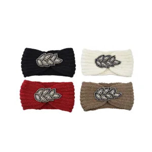Detailed close-up shot of the knitted rhinestone leaf headband showing fine beadwork and texture.
