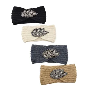 Detailed view of knitted rhinestone leaf headbands in four colors for winter warmth.