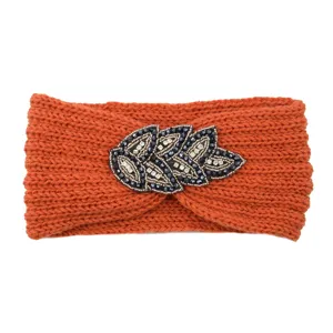 Knitted rhinestone headband detail showcasing beaded leaf embellishment and soft orange yarn.