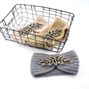 Detailed view of handmade knit headband featuring intricate beaded leaf applique and warm texture.
