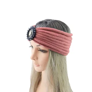 Dettaglio di fascia lavorata a maglia con strass, accessorio invernale color malva.