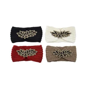 Knitted winter headband with beaded leaf decoration, warm and stylish hair accessory.