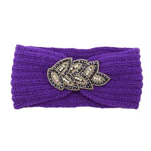Detailed shot of purple knitted winter headband with elegant beaded crystal leaf embellishment.