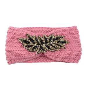 Pink knitted headband featuring a black and gold beaded leaf accent for women autumn winter.