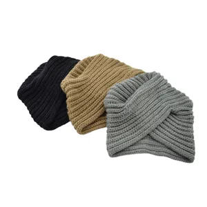 Closeup detail of three solid color knit twist beanies in black, khaki and grey for winter.