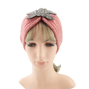 Detailed view of the pink knitted headband with sparkling beaded star motif for cozy winter style.