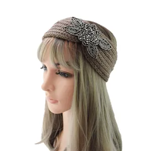 Detailed view of brown knitted wool headband with exquisite beaded floral decoration on mannequin.