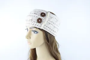 Nahaufnahme des beigen Strickstirnbandes mit doppelten Holzknöpfen und feiner Spitzenborte.