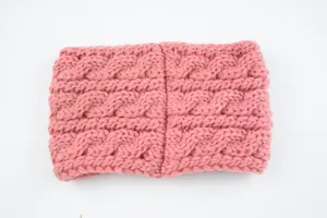 Close-up detail of the pink chunky cable knit winter headband showing its warm texture.