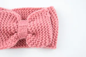 Detalle de diadema de punto rosa con lazo, accesorio para el pelo cálido de lana de invierno.