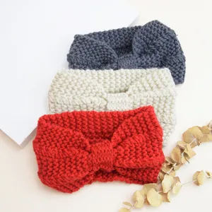 Detail view of chunky knit headbands, cozy winter wool ear warmers with cute bow design.