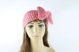 Diadema de punto rosa con gran lazo, accesorio para el cabello de invierno cálido y cómodo en detalle.
