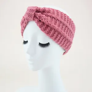Pink knitted headband for women, thick crochet ear warmer with stylish twist design detail.