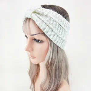 Detail shot of a cozy knit headband, winter warm ear warmer, twisted design in off white.