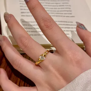 Vue détaillée de la bague en or élégante avec une pierre centrale ovale et des éclats.