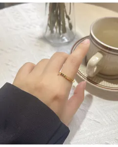 Gros plan détaillé d'une bague minimaliste en acier titane doré avec motif cœur au doigt