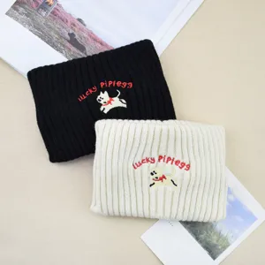 Close-up detail of cute dog embroidered knit headband, soft woolen warm winter hair band.