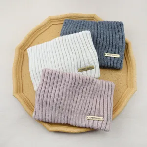 Knit headband set featuring warm double-layer wool material and chic metal tag detail.