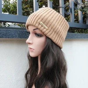 Detailed view of a stylish khaki knitted headband ear warmer featuring a metallic label accent.