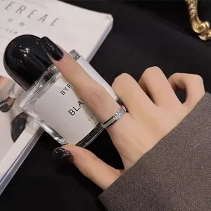 Gros plan détaillé de la bague en acier inoxydable et strass, style élégant porté au doigt.