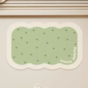 Detailed view of cute scalloped green bath mat featuring stylish polka dots and text.