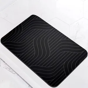 Detail shot of modern black diatomite bath mat with grey wavy lines, fast drying anti-slip.
