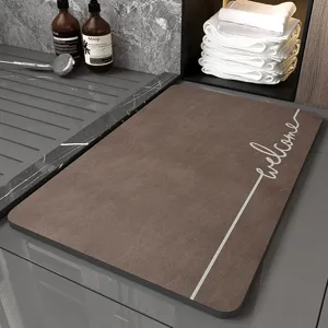 Detail view of brown diatomite bath mat featuring elegant welcome print and anti slip surface.