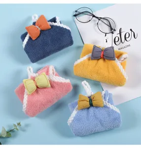 Detailed view of thick coral fleece hanging hand towel with cute bow, perfect for kitchen and bath.