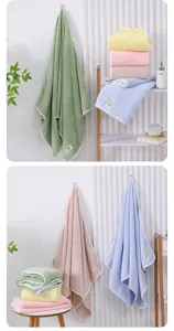 Solid color fleece bath towel detail showing soft coral fleece texture and cream piping edges.