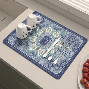 Vista dettagliata del tappetino scolapiatti con motivo mandala blu e tazze eleganti.