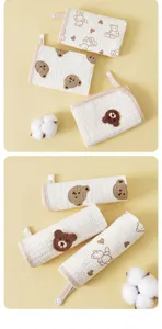 Close-up of multi-layer gauze baby face towels with cute bear embroidery and hanging loops.