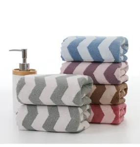 Vista dettagliata di asciugamani in pile corallo con motivo chevron per uso domestico quotidiano.