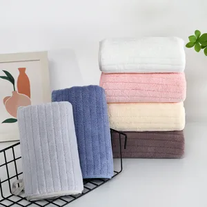 Serviette de visage rayée en polaire corail douce, épaisse et absorbante pour un usage quotidien.